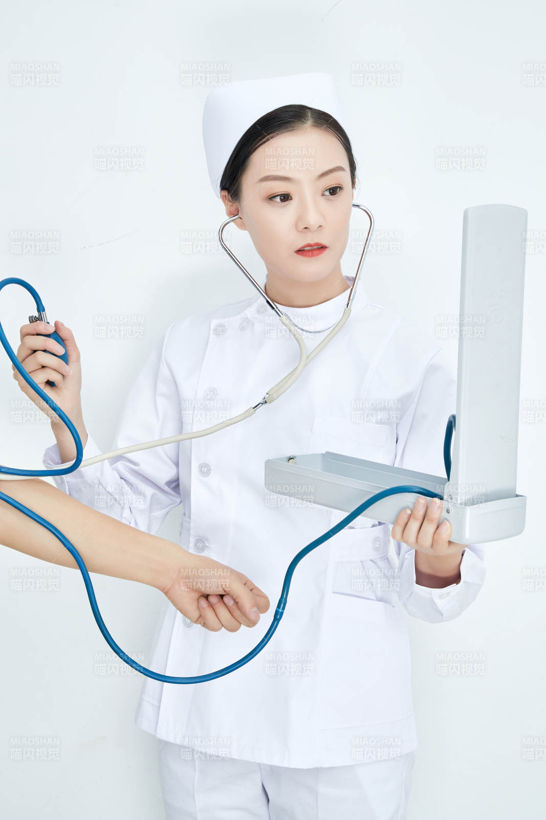 白色背景下手持血压计测量血压的医生图片