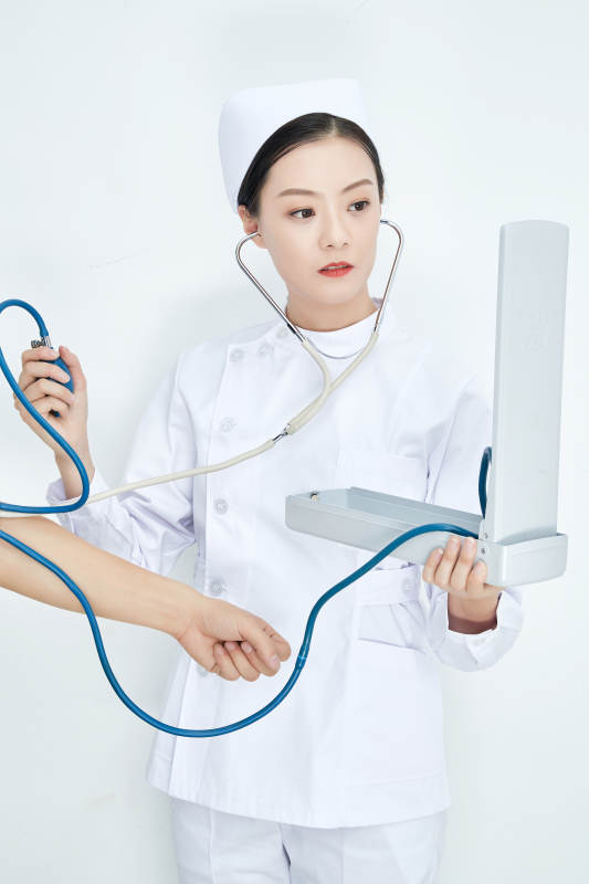 白色背景下手持血压计测量血压的医生图片