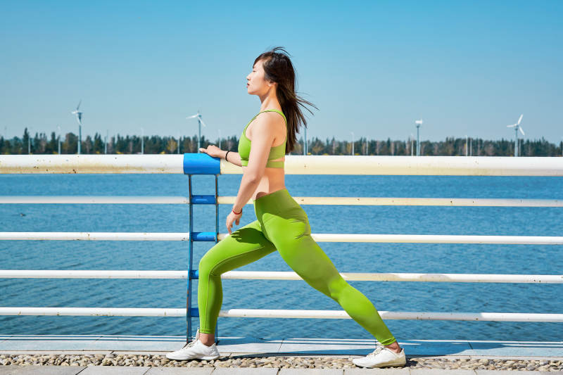 户外河畔公园做拉伸有氧运动的亚洲女性图片