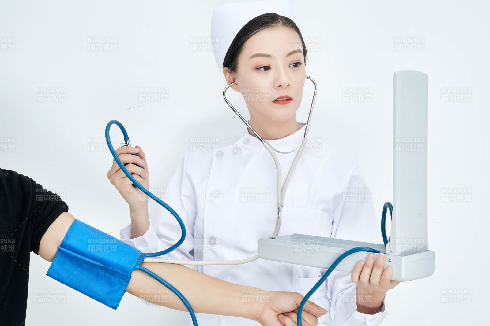 白色背景下手持血压计测量血压的医生图片