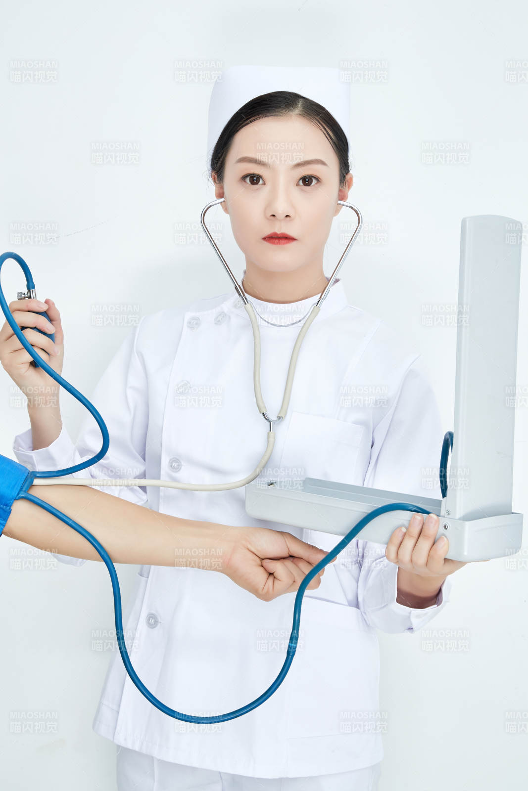白色背景下手持血压计测量血压的医生图片