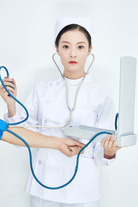 白色背景下手持血压计测量血压的医生图片
