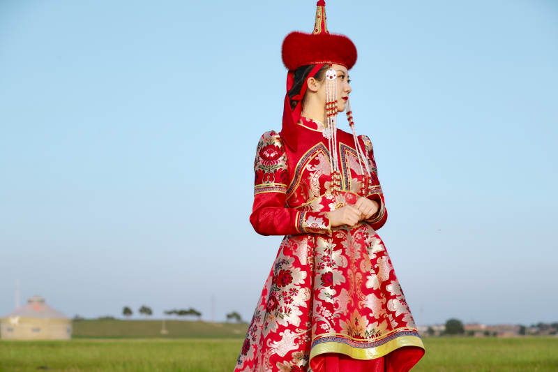 草原上穿着蒙古族传统服饰的亚洲年轻美少女图片