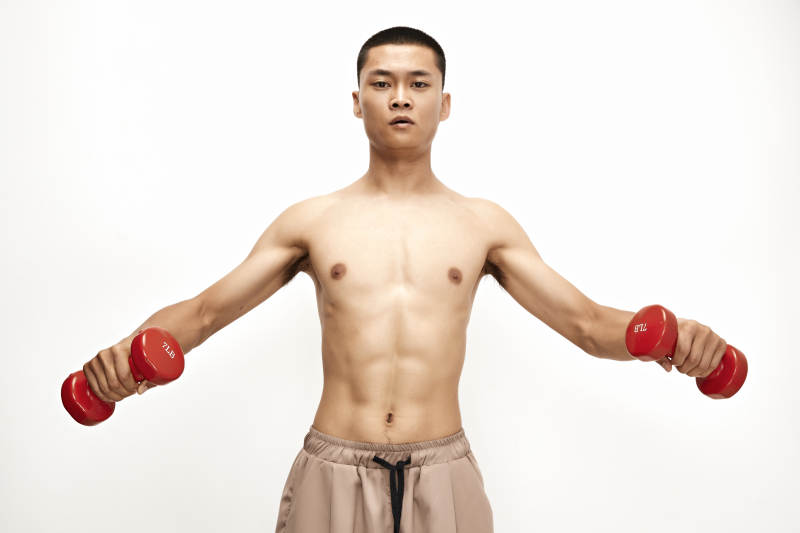 使用哑铃进行健身锻炼的亚洲男性图片
