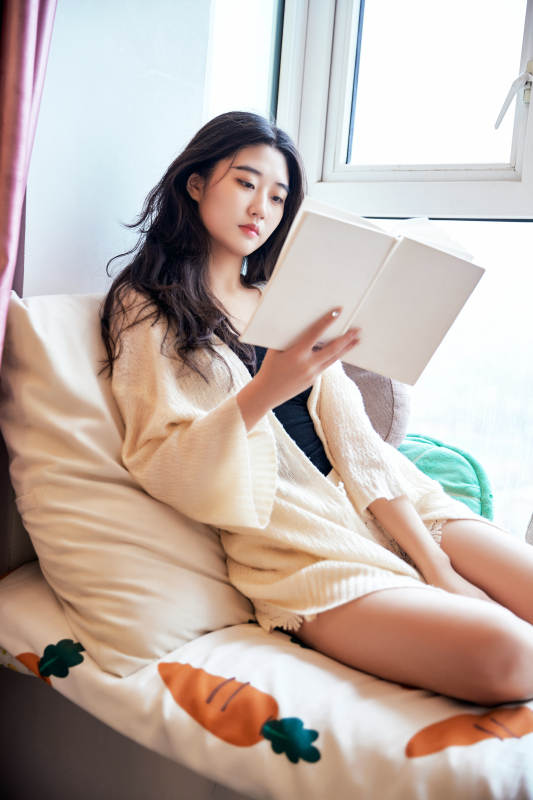 躺在舒适的飘窗上看书的女孩图片