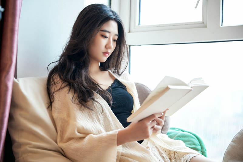 躺在舒适的飘窗上看书的女孩图片