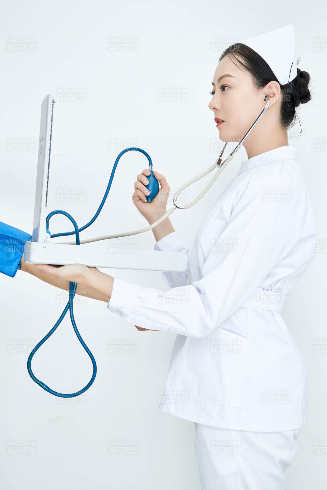 白色背景下手持血压计测量血压的医生图片