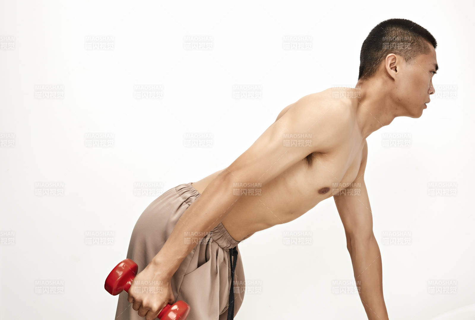 使用哑铃进行健身锻炼的亚洲男性图片