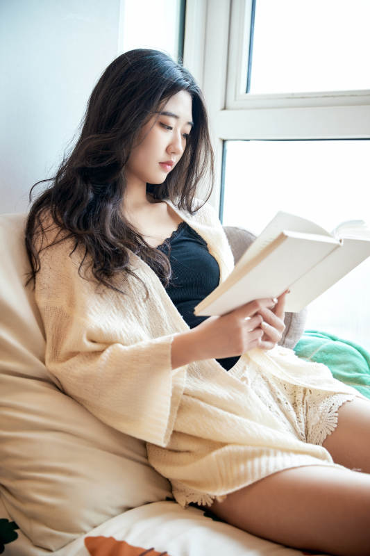 躺在舒适的飘窗上看书的女孩图片
