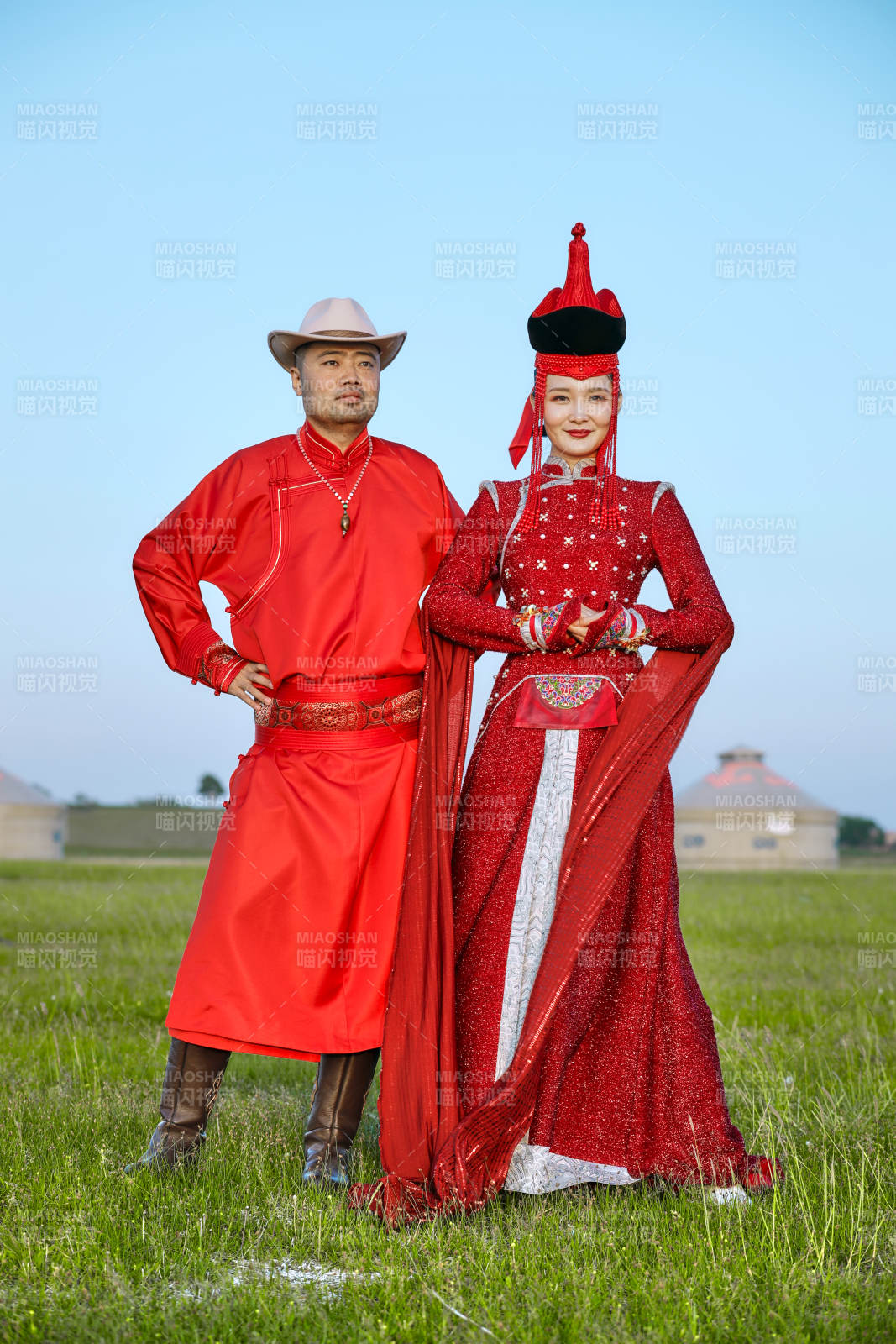 草原上蒙古包前穿蒙古族传统服饰的年轻夫妻图片