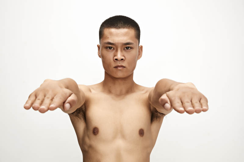 白色背景下演示自由搏击动作的亚洲功夫男性图片