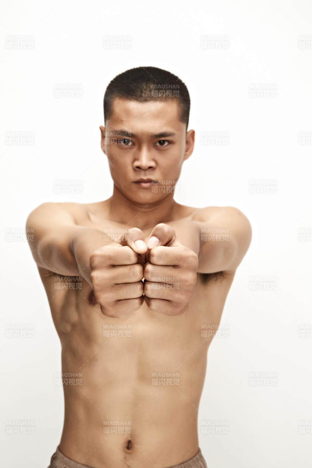 白色背景下演示自由搏击动作的亚洲功夫男性图片