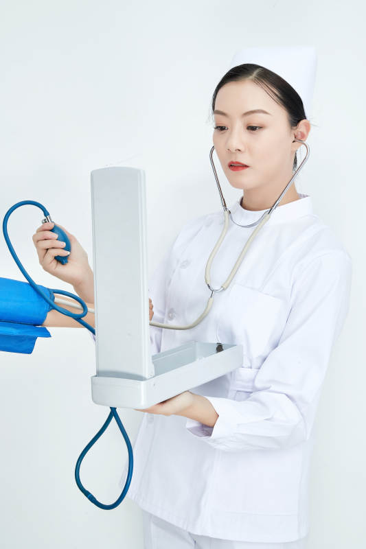 白色背景下手持血压计测量血压的医生图片
