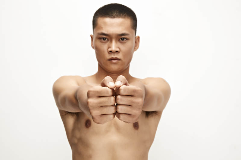 白色背景下演示自由搏击动作的亚洲功夫男性图片