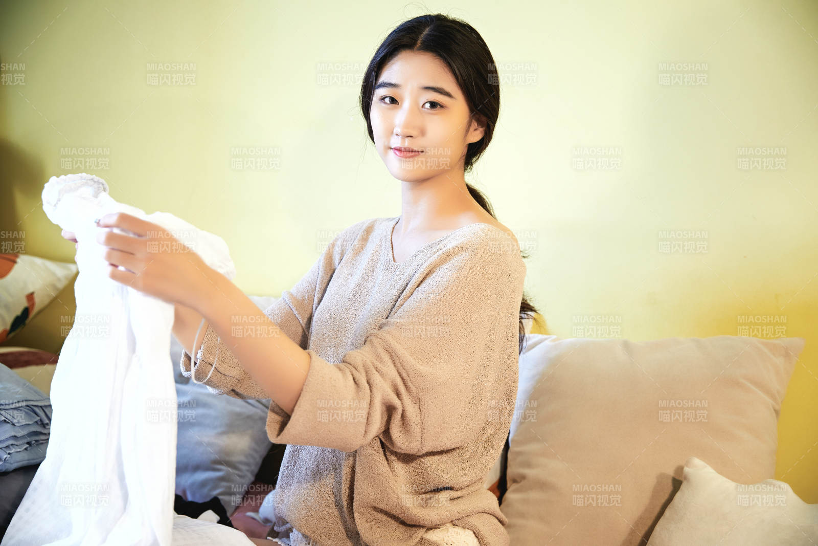 在沙发床上整理行装的年轻亚洲女性图片