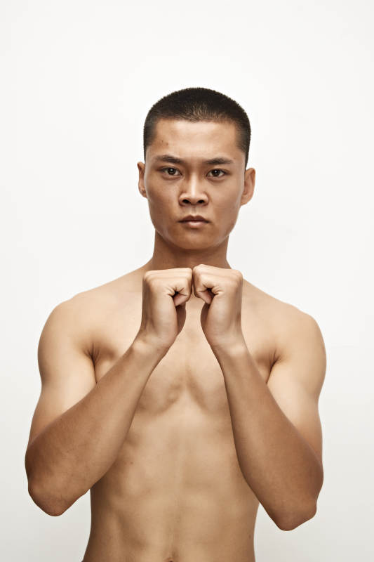 白色背景下演示自由搏击动作的亚洲功夫男性图片