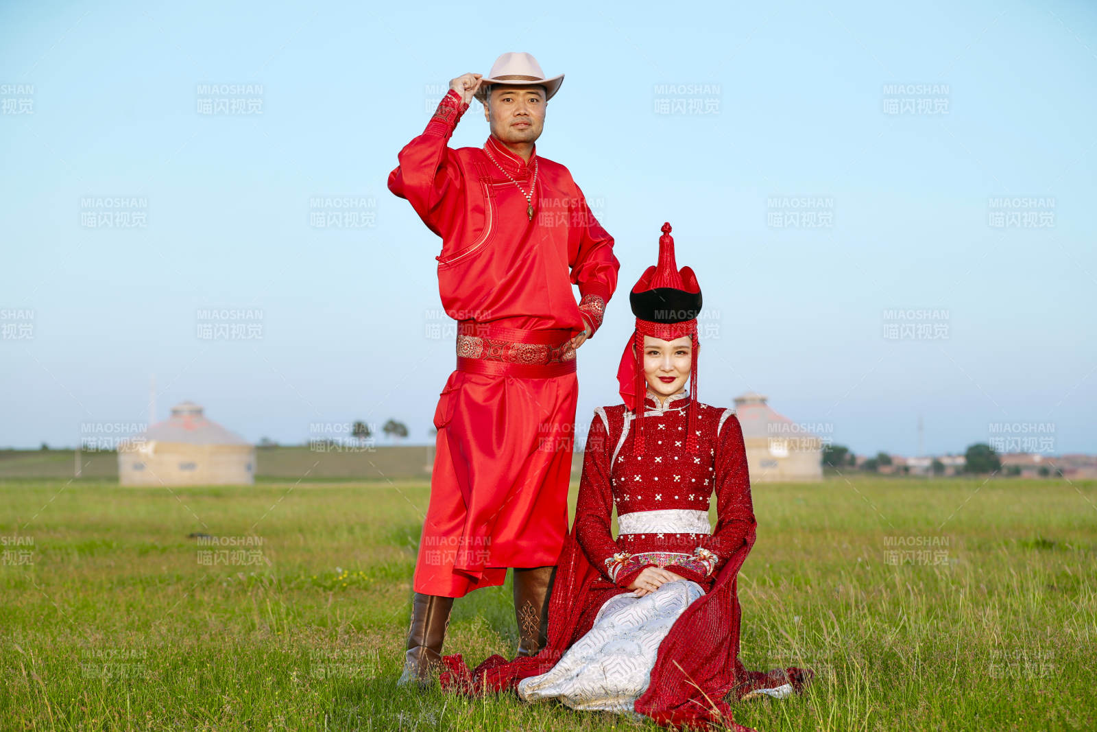 草原上蒙古包前穿蒙古族传统服饰的年轻夫妻图片