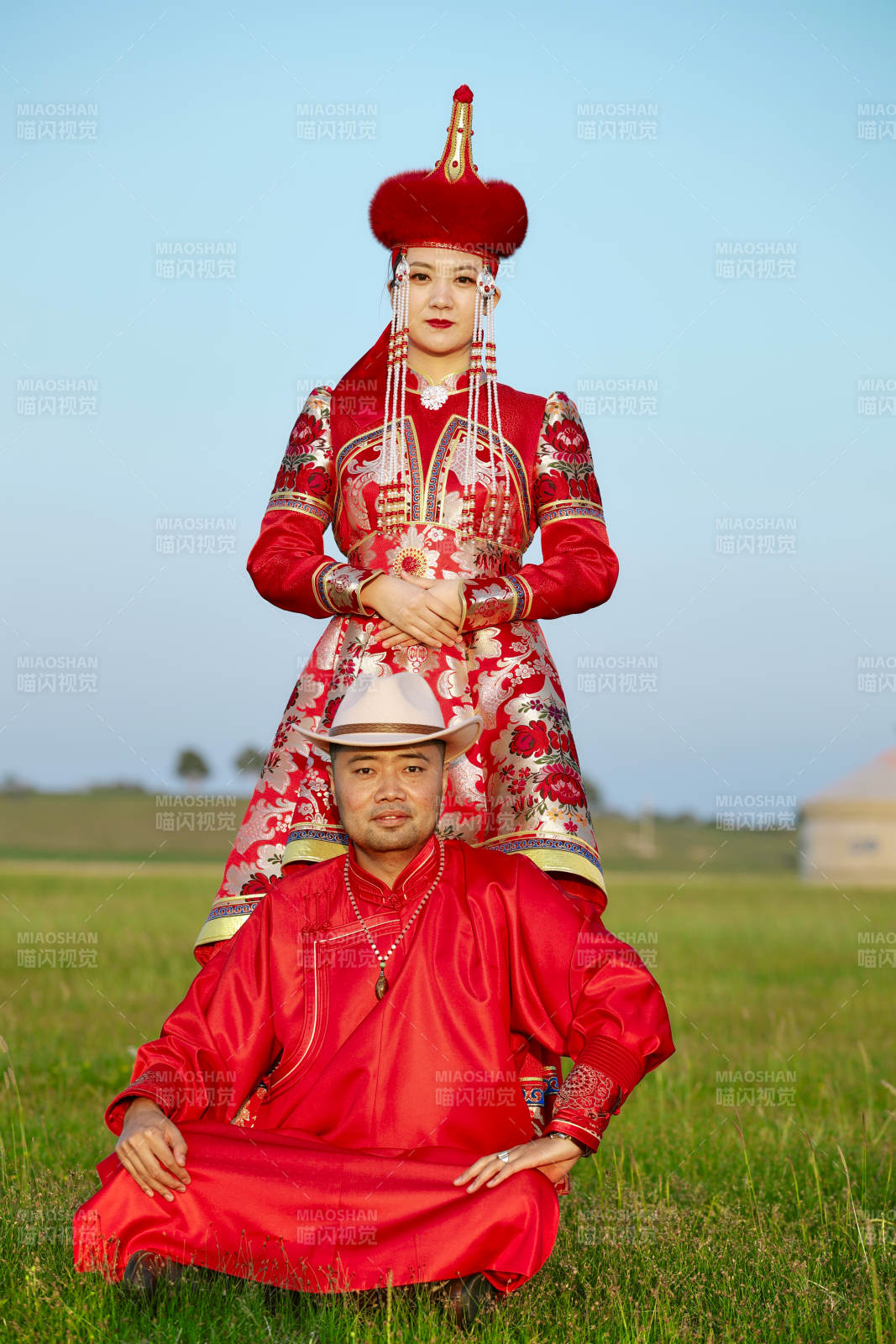 草原上蒙古包前穿蒙古族传统服饰的年轻夫妻图片