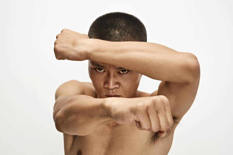 白色背景下演示自由搏击动作的亚洲功夫男性图片