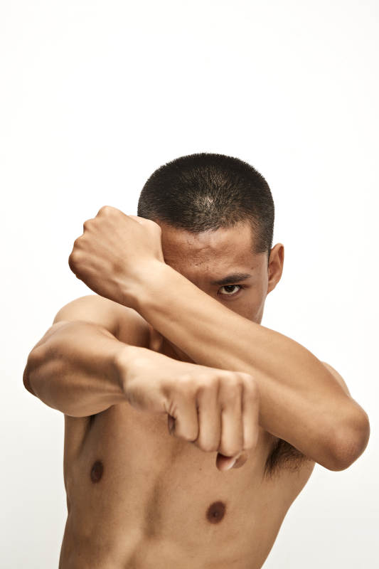 白色背景下演示自由搏击动作的亚洲功夫男性图片