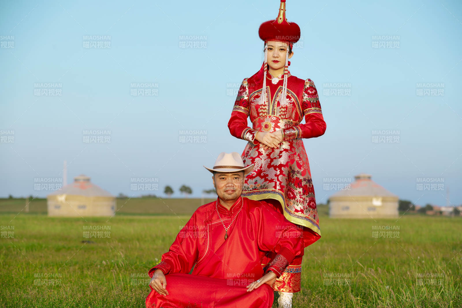 草原上蒙古包前穿蒙古族传统服饰的年轻夫妻图片