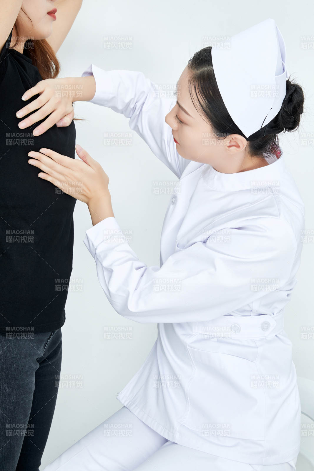 年轻的女性医护人员为患者进行胸部检查图片