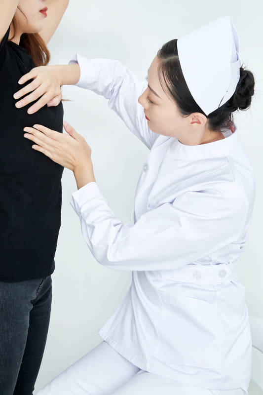 年轻的女性医护人员为患者进行胸部检查图片