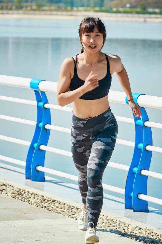 户外河畔公园进行跑步锻炼的亚洲女性图片