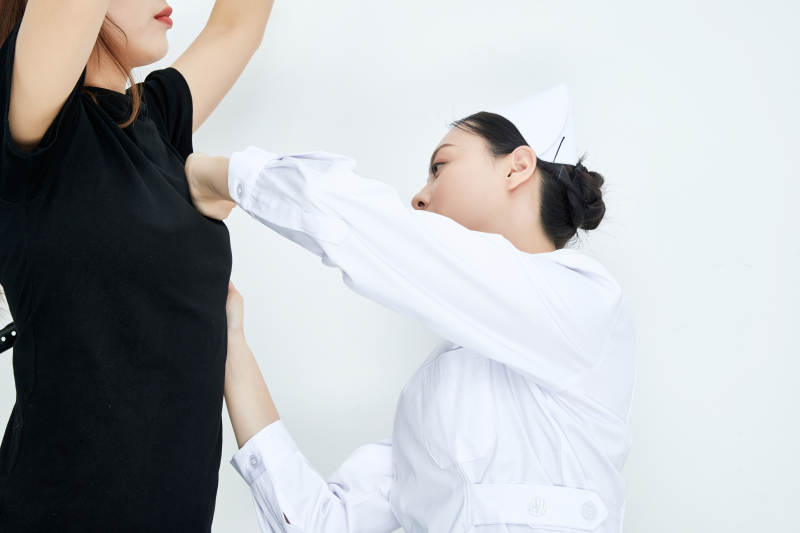 年轻的女性医护人员为患者进行胸部检查图片