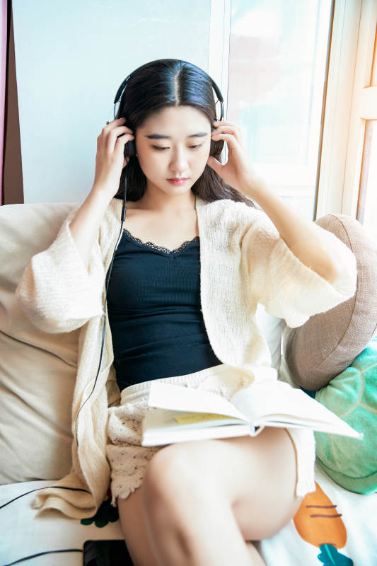 躺在舒适的飘窗上听音乐看书玩手机的女孩图片