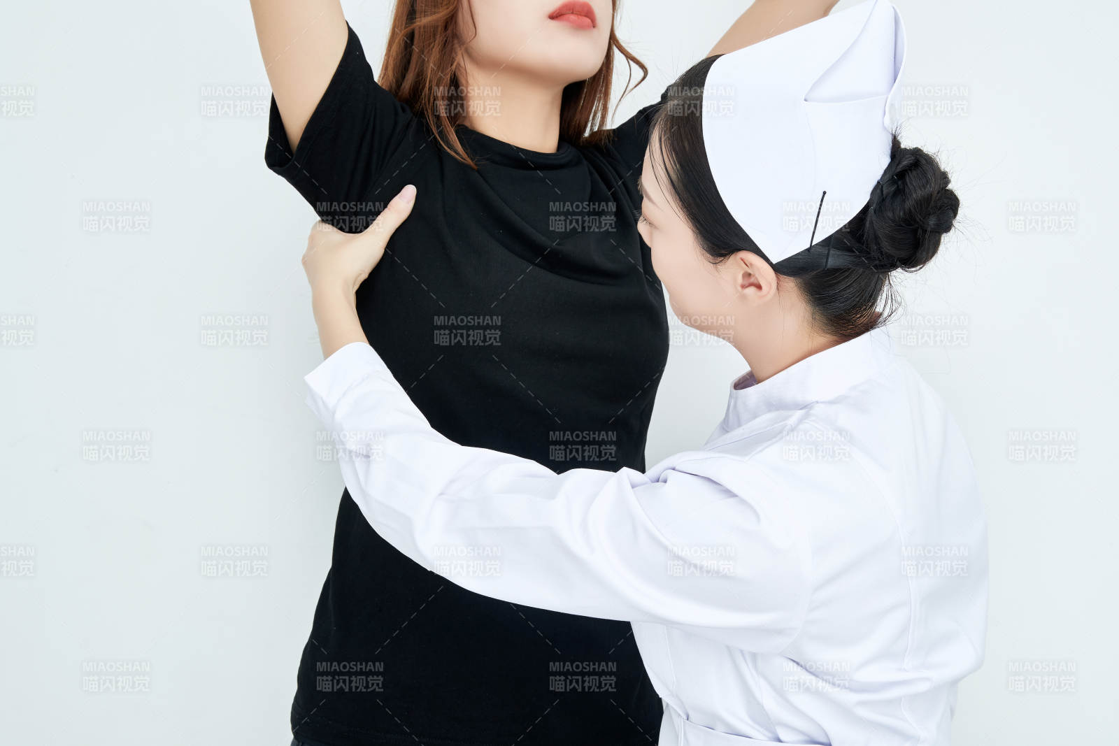 年轻的女性医护人员为患者进行胸部检查图片