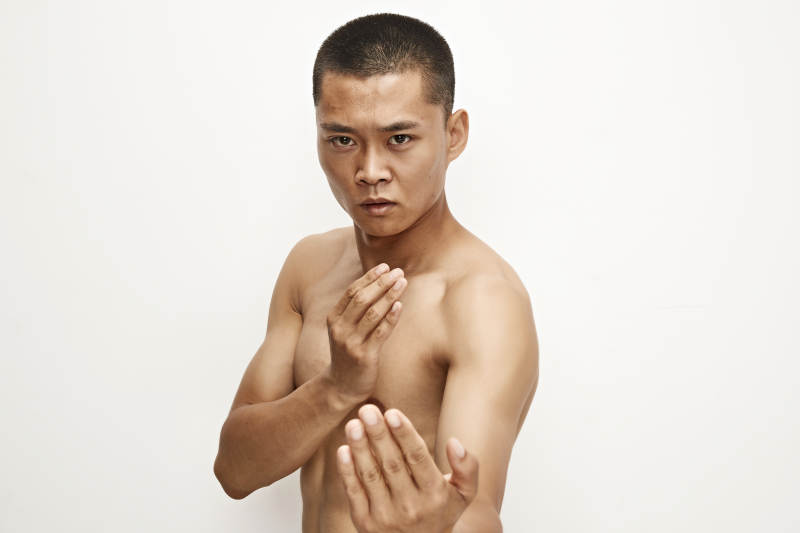 白色背景下演示自由搏击动作的亚洲功夫男性图片