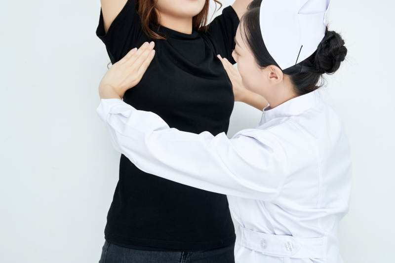 年轻的女性医护人员为患者进行胸部检查图片