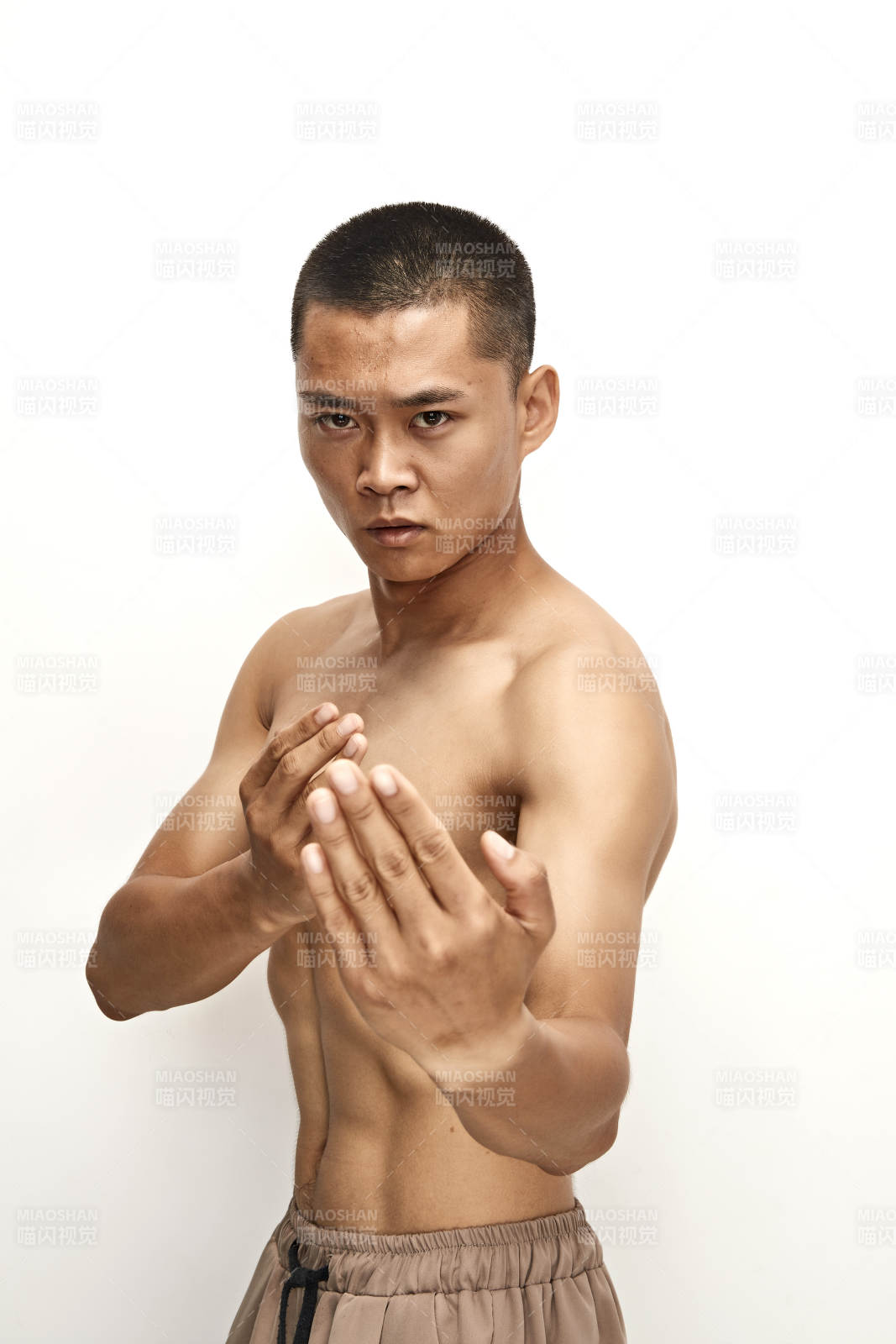 白色背景下演示自由搏击动作的亚洲功夫男性图片