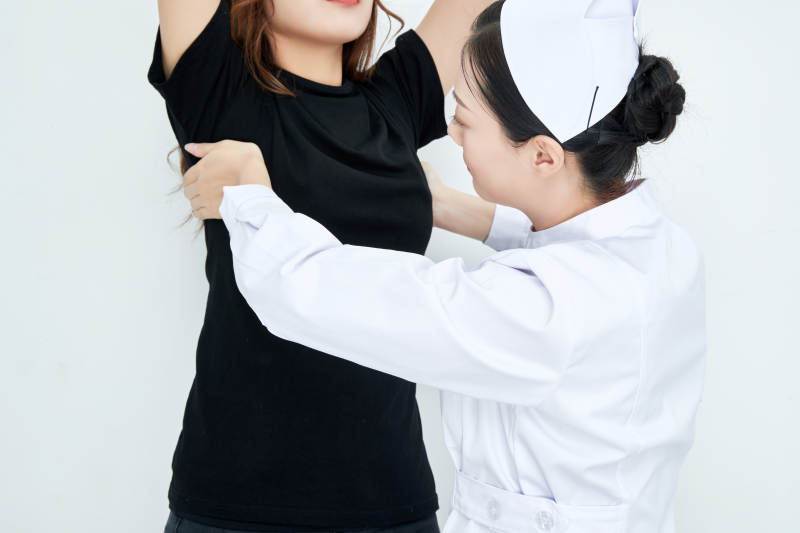 年轻的女性医护人员为患者进行胸部检查图片