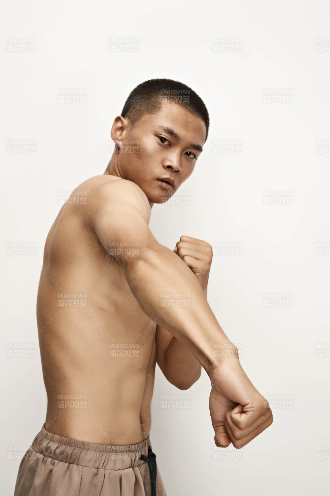 白色背景下演示自由搏击动作的亚洲功夫男性图片