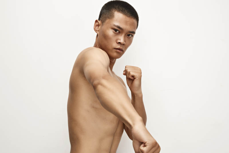 白色背景下演示自由搏击动作的亚洲功夫男性图片