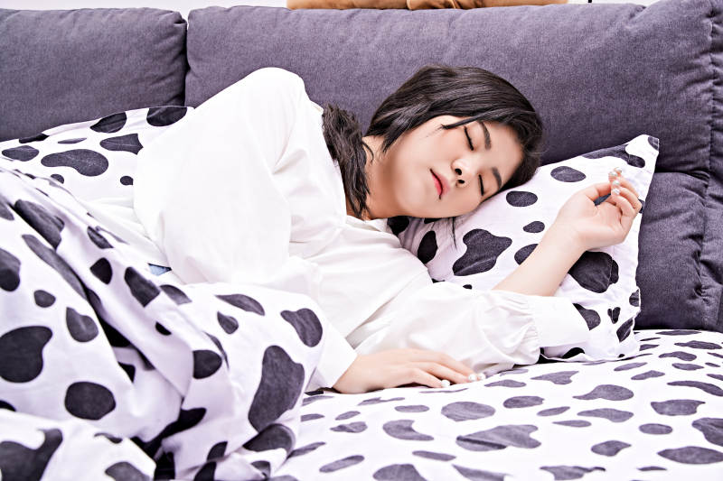 年轻女性睡在在舒适的床上图片