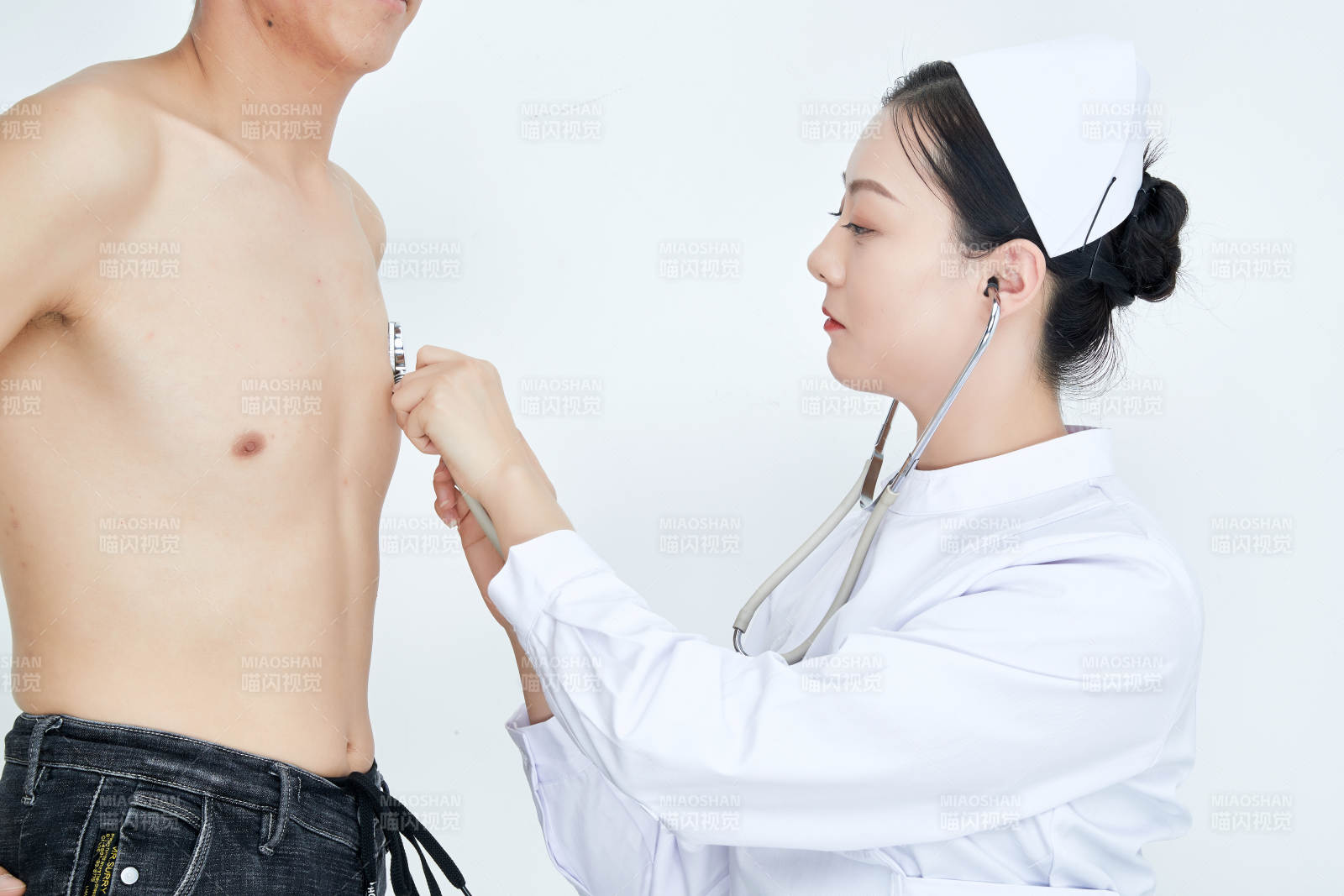 佩戴听诊器的女性医护人员为患者听诊检查图片