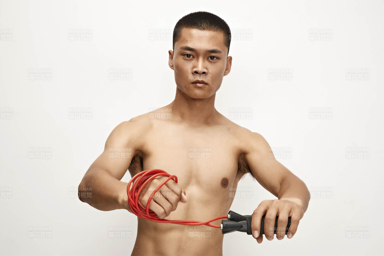 白色背景下手持运动跳绳的亚洲健身男士形象图片