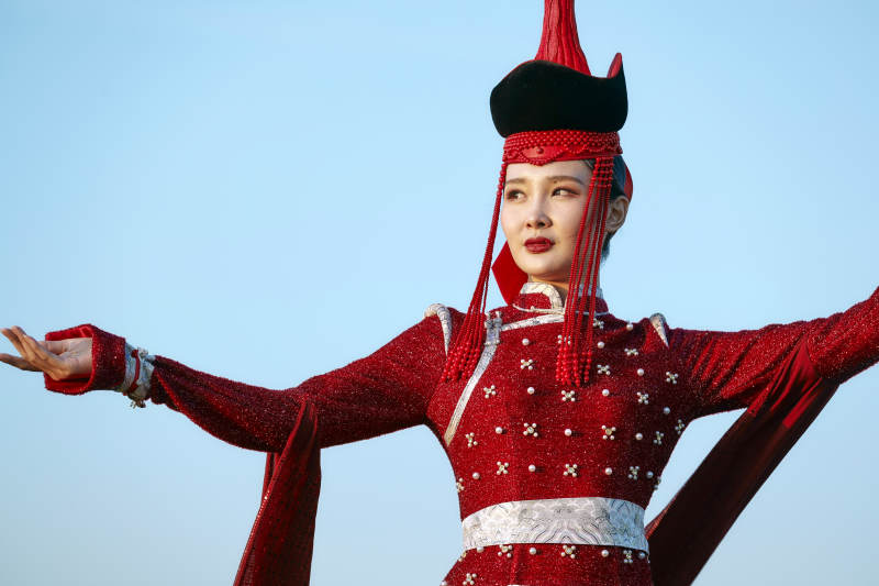 草原上穿着蒙古族传统服饰的亚洲年轻美少女图片