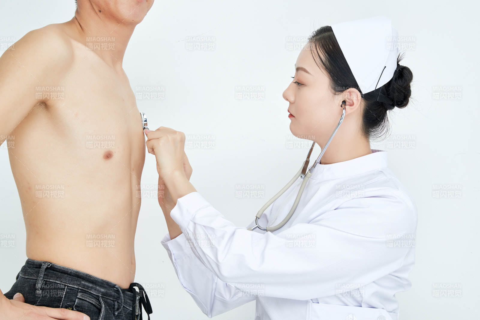 佩戴听诊器的女性医护人员为患者听诊检查图片