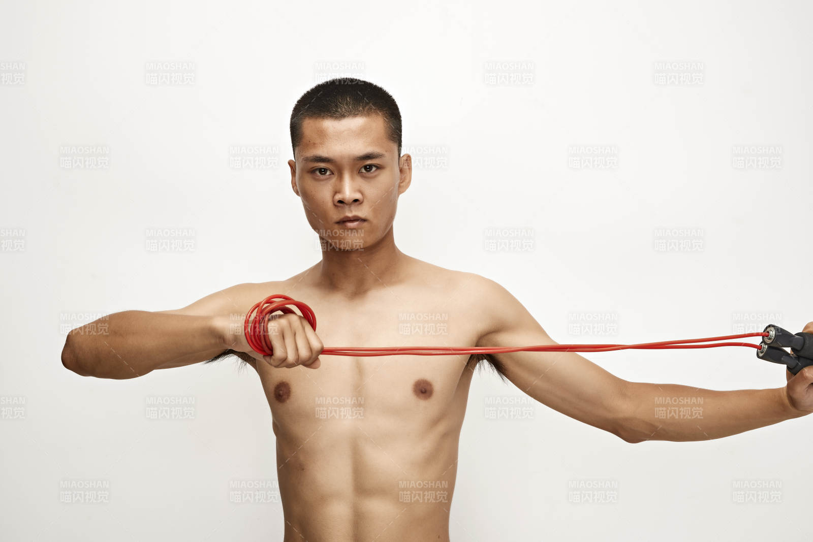 白色背景下手持运动跳绳的亚洲健身男士形象图片