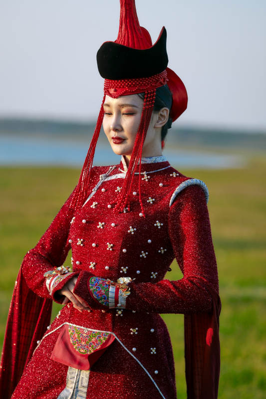 草原上穿着蒙古族传统服饰的亚洲年轻美少女图片