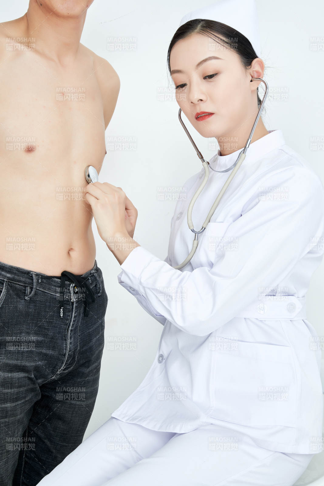 佩戴听诊器的女性医护人员为患者听诊检查图片