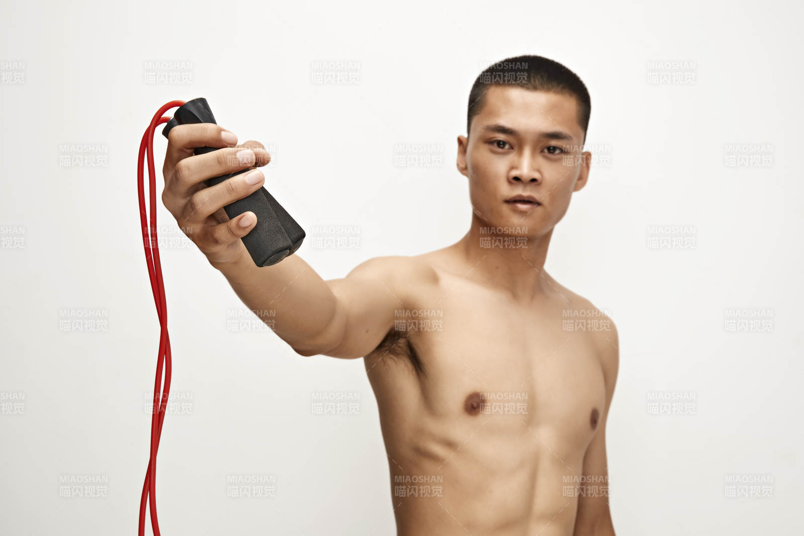 白色背景下手持运动跳绳的亚洲健身男士形象图片