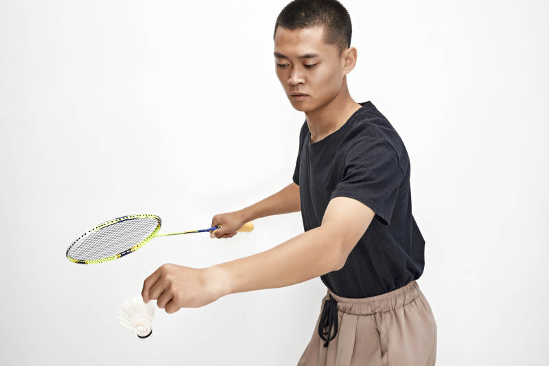 白色背景下健硕的亚洲羽毛球运动员形象图片