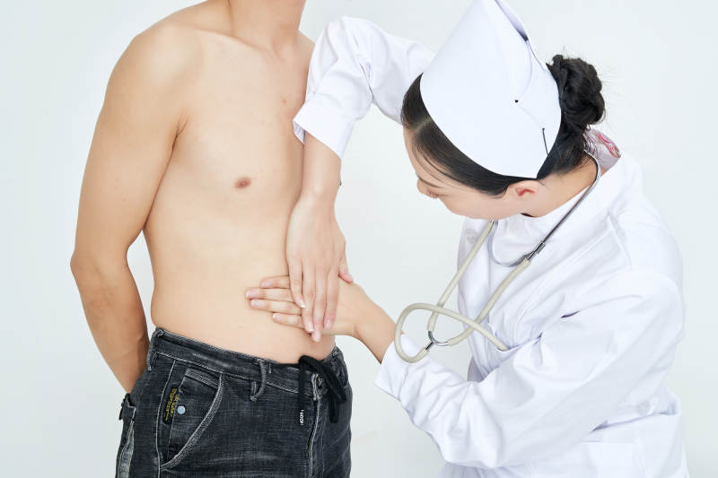 年轻的女性医护人员为患者进行身体按压检查图片