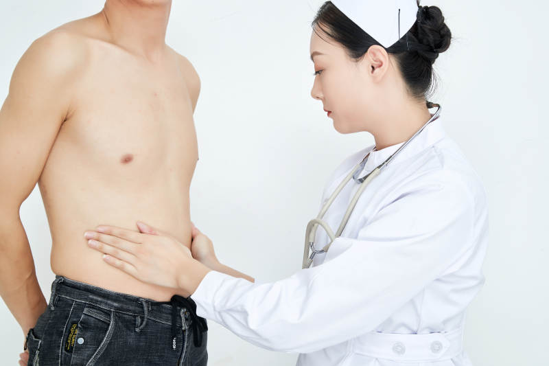 年轻的女性医护人员为患者进行身体按压检查图片