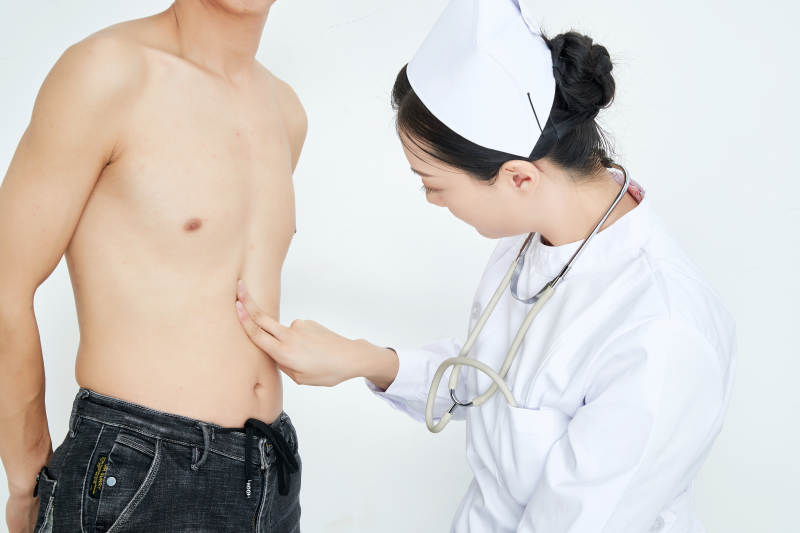 年轻的女性医护人员为患者进行身体按压检查图片